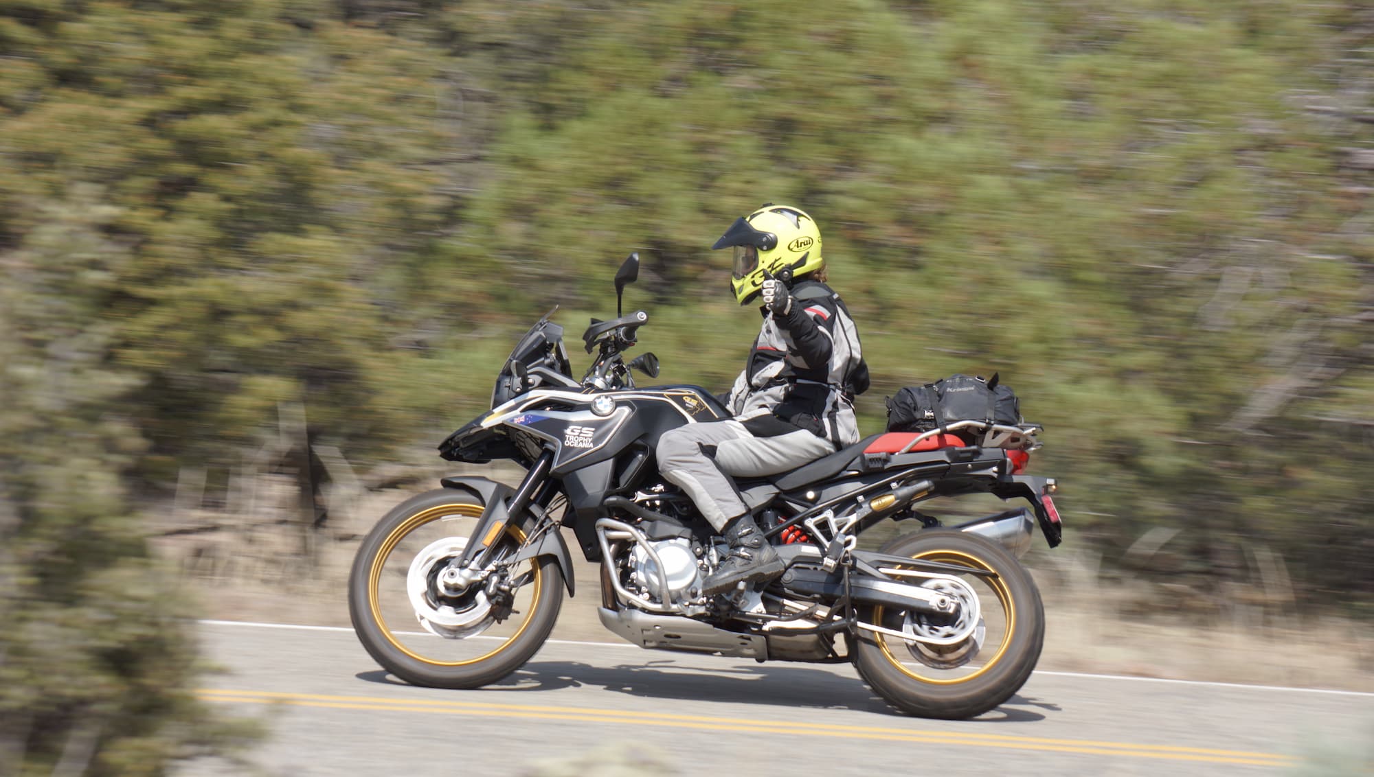 a person riding a motorcyle wearing a yellow helmet